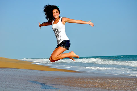 Woman jumping in the beach.