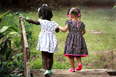 Little girls walking on a bridge.