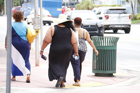 Overweight people walking on the street.
