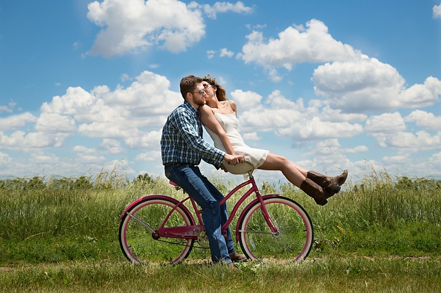 Couple on bike over a filed