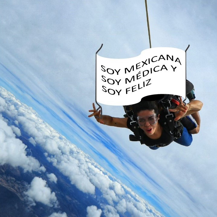 Persona en paracaídas mostrando mensaje en una pancarta