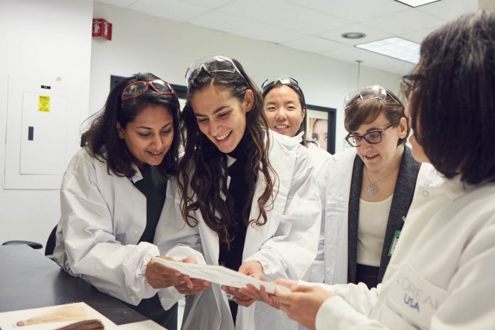 Mujeres científicas en un laboratorio revisando un documento