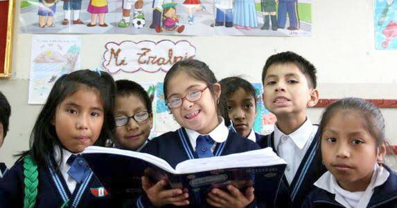 Niñas y niños leyendo en un salón de clases